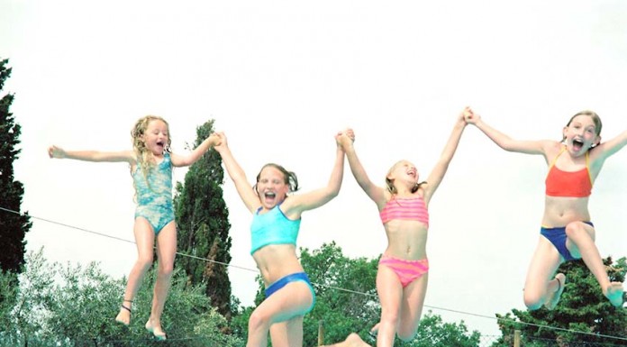 Brincadeiras saudáveis na água Girls playing at the pool --- Image by © Royalty-Free/Corbis